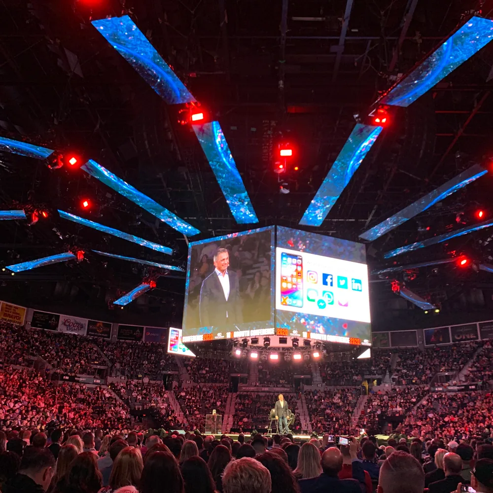 Ryan Deiss on an arena stage in the round, crowd filling the stands